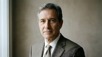 Middle-aged man with dark hair and light complexion wearing formal business attire including gray blazer and tie, professional portrait for corporate, executive, or business use.