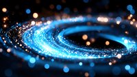 Glowing blue spiral of light particles with bokeh effect on dark background creates dynamic motion trail, abstract cosmic energy visualization.