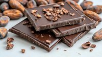 Dark chocolate bars stacked with crushed cacao nibs and raw cocoa beans scattered around on wooden surface, macro food photography with selective focus.