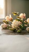 Fresh magnolia flowers with pink blush petals and green buds arranged on rustic wooden surface in soft natural window light for spring decor and floral design.