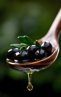 Fresh black olives on wooden spoon with dripping olive oil and rosemary leaves against dark green background, macro food photography.
