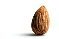 Single fresh almond nut with detailed texture and natural brown color isolated on white background, ready for design use in food packaging and advertising.
