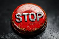 Vintage red metal bottle cap with embossed STOP text on dark background. Macro photography shows weathered texture and rustic details creating dramatic contrast.