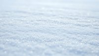 Fresh snow surface with sparkling crystals creating natural winter texture for seasonal backgrounds and cold weather concepts.