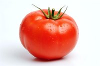 Fresh ripe red tomato with water droplets isolated on white background, perfect for food packaging, cooking blogs, and healthy lifestyle marketing materials.