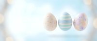Three decorated Easter eggs with pastel patterns floating on soft dreamy background with bokeh lights for spring holiday celebrations and greeting cards.