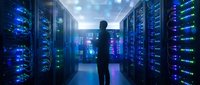 Male IT professional silhouette standing in modern data center server room with blue LED lights and network equipment for technology concepts.