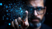 Bearded man in glasses touching glowing blue particles in dark space, creating futuristic interactive visualization effect. Technology concept for digital innovation.