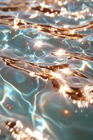 Sparkling water surface with golden light reflections creating magical ripples and starbursts against turquoise waves, abstract nature background for dreamy designs.