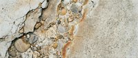 Cracked concrete surface with weathered texture and peeling paint, showing aged deterioration and wear patterns suitable for backgrounds and industrial design projects.