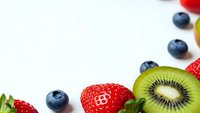 Fresh mixed berries and kiwi fruit arranged on white background with copy space for healthy eating and nutrition concepts.
