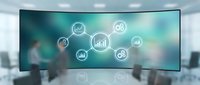 Curved digital display showing interconnected business analytics icons and data visualization symbols in modern office environment with blurred background.