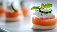 Fresh carrot and mozzarella appetizer stacks garnished with basil leaves, cream and black sesame seeds on white plate, selective focus macro shot.