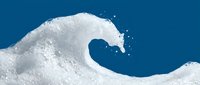 Foamy soap wave curling against a vivid blue background, capturing the dynamic motion of white lather in a creative liquid art concept.