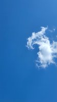 Bright blue sky with fluffy white clouds on sunny day for nature backgrounds and weather concepts.