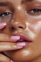 Close-up of glowing skin with pink manicured nails touching glossy lips, featuring dewy complexion, freckles and natural makeup for beauty and cosmetic advertising.