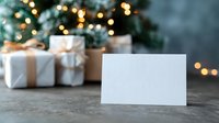 Blank greeting card with wrapped Christmas gifts and festive bokeh lights in background, perfect for holiday messages.