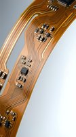 Flexible printed circuit board with copper traces and electronic components on polyimide substrate for modern device manufacturing and assembly.