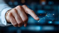 Male hand pointing at glowing digital financial chart with market data visualization in dark blue background with bokeh lights and trading statistics.