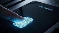 Biometric fingerprint scanner with glowing blue authentication on dark device screen showing access granted security technology for digital protection.