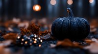 Black pumpkin with water drops on dark background with autumn leaves and bokeh lights creating mysterious Halloween atmosphere.