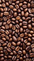 Fresh roasted coffee beans background showing natural variations in color and texture. Close up macro photography reveals rich brown tones and distinctive shapes.