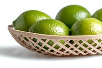 Fresh green limes in woven bamboo basket on white background, close-up view showing textured citrus skin. Minimal food photography for healthy cooking and drinks.