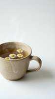 Rustic ceramic mug filled with hot water and floating white daisy flowers, steam rising, isolated on white background for wellness and herbal tea designs.