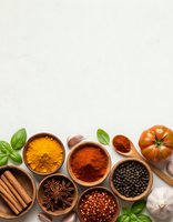 Colorful spices and herbs in wooden bowls with fresh tomato, garlic and basil leaves arranged on light background for cooking and culinary projects.