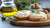 Fresh poached eggs on toasted bread with rosemary garnish served on wooden board. Healthy breakfast meal with olive oil and herbs in modern kitchen setting.