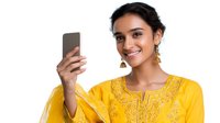 Young South Asian woman in bright yellow traditional embroidered dress taking selfie with smartphone, wearing gold tassel earrings and showing cheerful expression.