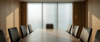 Modern corporate boardroom with wooden conference table and leather chairs facing large windows with natural light streaming in creating professional meeting space.