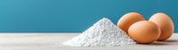 Fresh brown eggs and white flour pile on wooden surface against blue background for baking and cooking recipes.