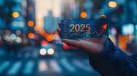 Hand holding mobile phone displaying 2025 growth chart against blurred urban cityscape with bokeh lights at dusk, representing future business success and digital transformation.