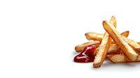 Golden crispy french fries piled on white background with red ketchup dipping sauce, isolated food photography for restaurant menu and advertising designs.