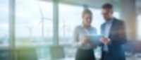 Blurred business professionals discussing documents in modern office with large windows and city view background for corporate presentations.