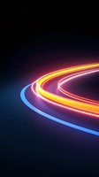 Glowing curved neon light trails in blue, orange, and pink colors against dark background create dynamic motion effect for technology and speed concepts.