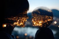 Double exposure silhouette of couple against illuminated cityscape at night, combining romantic mood with urban landscape in creative photography.