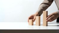 Business professional arranging wooden blocks in ascending order representing growth, progress and strategic planning for corporate success.
