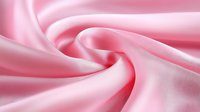 Soft pink silk fabric with elegant folds and waves creating smooth texture and luxurious sheen, suitable for fashion, wedding and romantic design backgrounds.