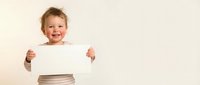Happy young Caucasian boy holding blank white paper sign with excited expression, perfect for advertising and promotional campaigns on neutral background.