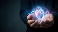 Businessman hands holding glowing digital heart with electric energy waves for healthcare technology and medical innovation concepts.