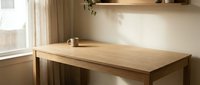 Minimalist wooden desk in bright home office with natural light from window, clean workspace setup for productivity and remote work.
