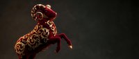Ornate red velvet Christmas stocking with golden baroque scrollwork pattern hanging against dark background for holiday decorations and festive designs.