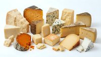 Assorted gourmet cheese collection featuring aged cheddar, blue cheese, brie, gouda and artisanal varieties arranged on white background for culinary use.
