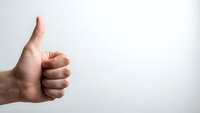 Hand showing thumbs up gesture on white background for positive feedback and approval concepts.