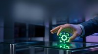 Businessman in blue shirt holding hand over glowing green gear icon on digital surface, representing technology, innovation, and industrial solutions for business operations.