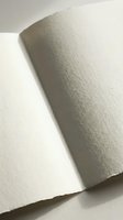 Textured cream paper sheets with rough edges creating elegant shadows and depth for stationery design projects.