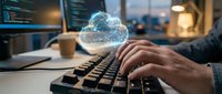 Hands typing on keyboard with glowing cloud computing hologram in modern office workspace for digital transformation and data storage solutions.
