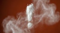 White flour exclamation mark symbol floating in cloud of powder dust against warm brown background for baking and cooking concepts.